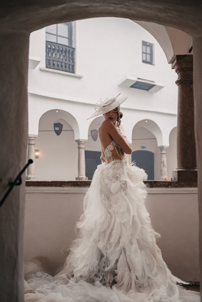 Eine Braut in einem Couture Brautkleid steht unter einem Torbogen in Bamberg.
