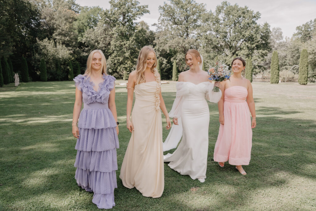 Die Braut läuft mit ihren Brautjungfern lachend über die Wiese im Schloss Thurn in Heroldsbach.