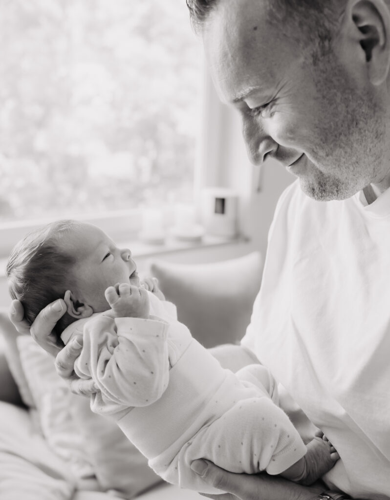 Neugeborenes Baby wird von den Händen seinem Papa gehalten in Forchheim.