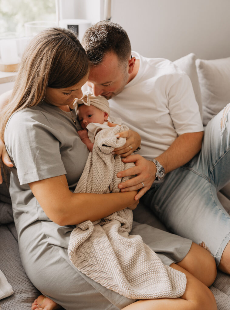 Neugeborenes Baby wird von den Händen seinen Eltern gehalten in Forchheim.