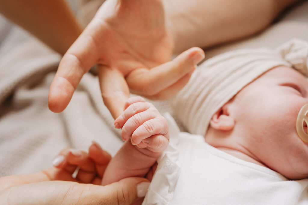 Neugeborenes Baby umfasst mit seiner kleinen Hand den Finger vom Papa in Heroldsbach