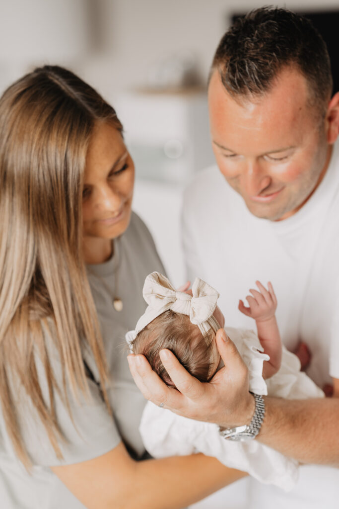Neugeborenes Baby wird von den Händen seiner Familie gehalten in Forchheim.