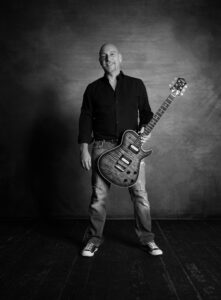 Sänger und Gitarrist stehend mit Gitarre