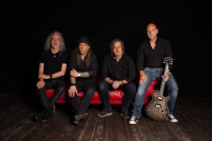 Rockband sitzend auf rotem Sofa